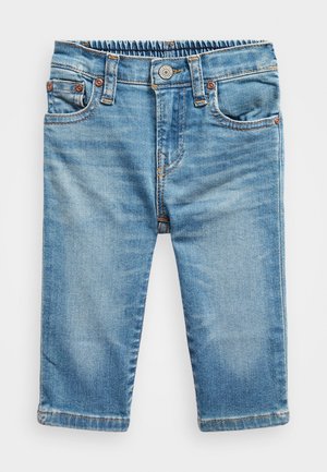Blå denim bukser til småbørn med elastisk talje, knaplukning og forlommer, vist mod en ensfarvet hvid baggrund.