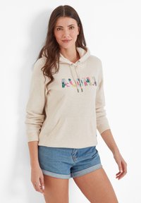 Beige hoodie with a front pocket, featuring colorful floral "ALOHA" design. Long sleeves, drawstring hood, and soft texture. Worn with blue denim shorts.
