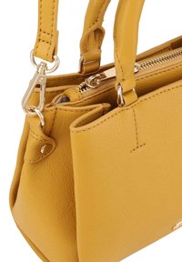 Gele leren handtas met een gestructureerde oppervlakte, voorzien van gouden hardware, dubbele korte handvaten en een ritssluitingscompartiment.