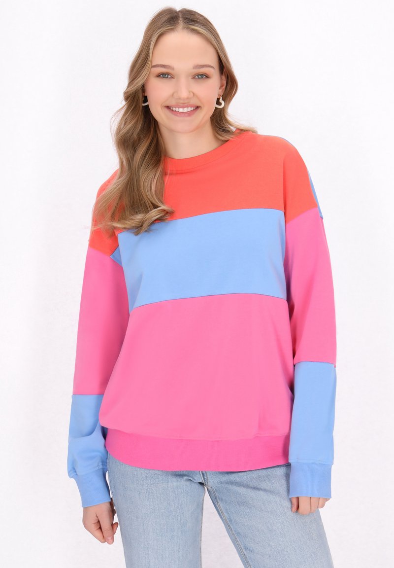 Maglione a maniche lunghe multicolore con sezioni di tessuto rosso, rosa e blu. Morbido al tatto e con una vestibilità rilassata.
