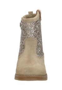 Beige suède enkellaars met een glinsterende zilveren achterkant, ronde neus en een lus om aan te trekken. Heeft een soepele textuur en een rubberen zool voor grip.