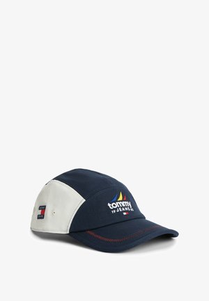 Granatowo-biała czapka z daszkiem Tommy Jeans z haftowanym logo i kolorowym wzorem łodzi żaglowej z przodu, prezentowana na białym tle.