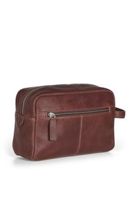 Brun lær toilettbag med rektangulær form, toppzip-lukking, frontlomme med glidelås, og bærehåndtak på siden.