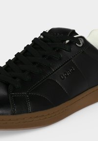 Baskets en cuir noir avec lacets noirs, semelle marron et col de talon blanc, avec le nom de la marque Boro sur le panneau latéral.