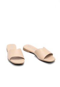 Beżowe klapki z gładkim, matowym wykończeniem, otwartym noskiem i płaską podeszwą. Brak widocznych ozdób lub wzorów.