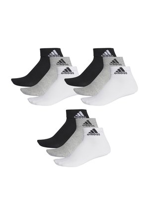 Four pairs of athletic ankle socks in black, gray, and white, featuring a ribbed cuff and embroidered black logo on the upper side.