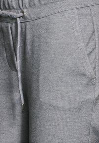 Grå joggerbyxor i texturerad tyg, med elastisk midja och dragsko samt sidfickor.
