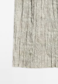 Tissu gris plissé avec une texture froissée, présentant des plis verticaux et une surface irrégulière pour un aspect en couches.