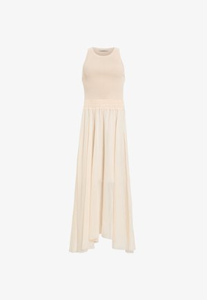 Hihaton, ribattua neulepuseroa vaaleassa kermassa, joka siirtyy hulmuavaan, laskostettuun hameeseen. Kootun vyötärönauhan rakenne lisää tekstuuria ja muotoa. Keskitason malli.