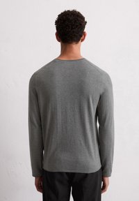 Langärmliges Shirt aus heather-grauer Baumwolle mit rundem Halsausschnitt und Raglanärmeln, das eine glatte Textur und einen feinen Stretch aufweist.