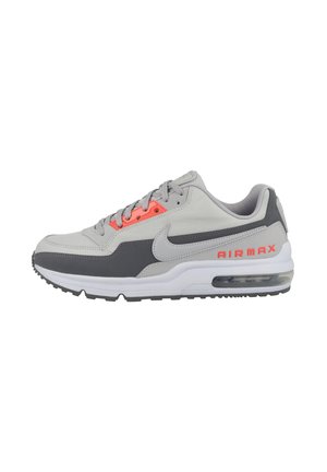 Gray athletic sneakers with a combination of smooth and textured materials. Features bright orange accents and a visible air unit in the sole.