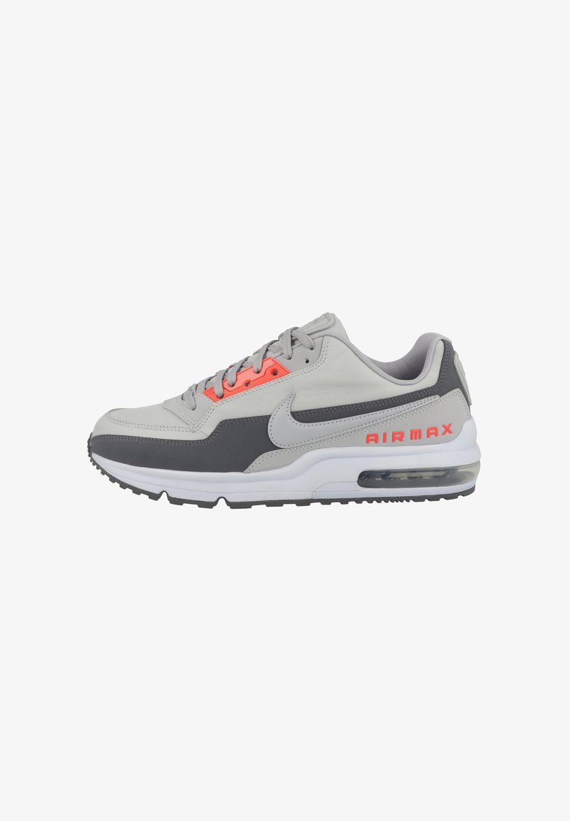 Gray athletic sneakers with a combination of smooth and textured materials. Features bright orange accents and a visible air unit in the sole.