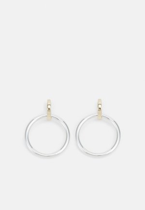 Silver hoop earrings with small gold rectangular clasps on a plain white background.