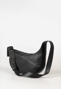 Borsa a tracolla in pelle nera con design curvo, superficie testurizzata, tracolla regolabile e chiusura con zip. Presenta accenti eleganti per la funzionalità.