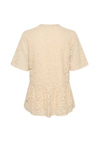 Top in pizzo color crema, con maniche corte, scollatura rotonda e orlo svasato. Motivi floreali caratterizzano la trama del pizzo.