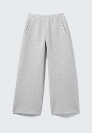 Pantalon de survêtement gris clair en tissu doux, doté d'une coupe à jambes larges, d'une ceinture élastique et de deux poches latérales.