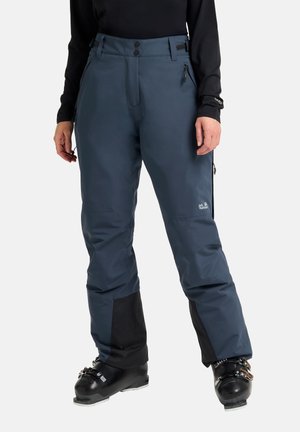 Pantaloni da sci impermeabili blu con vita alta, cerniere laterali e pannelli inferiori neri. Il materiale è liscio con una leggera lucentezza.