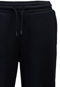 Schwarze Jogginghose mit einem Zugbandbund, aus weichem Material gefertigt, mit einer Seitentasche und einer glatten Textur.