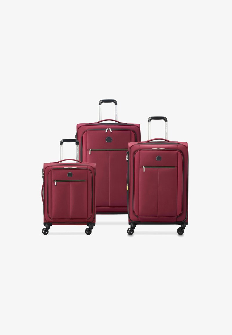 Three burgundy soft-shell suitcases of varying sizes with four wheels and telescopic handles, arranged side by side on a white background.