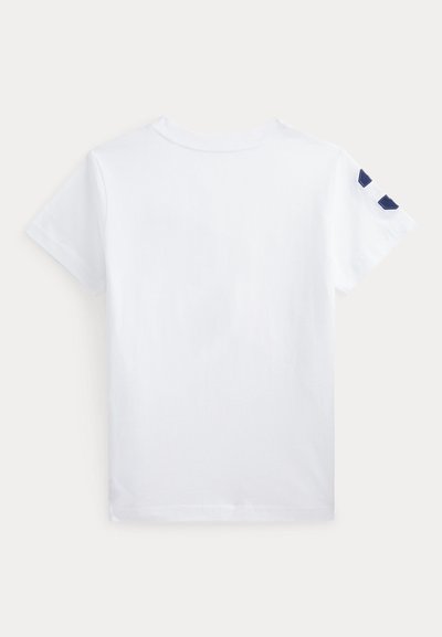 T-shirt branca de algodão com mangas curtas, apresentando detalhes em azul-marinho no ombro esquerdo. Textura suave e decote redondo clássico.