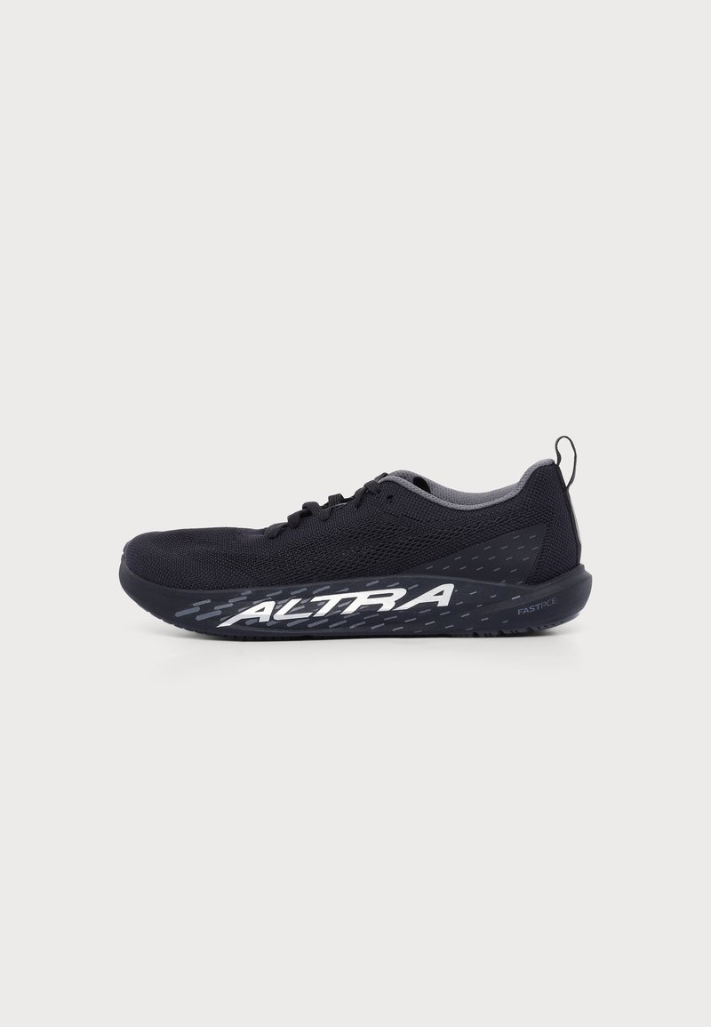 Chaussure de sport noire avec empeigne en mesh, semelle épaisse, grand logo blanc "ALTRA" sur le côté et languette au talon sur fond blanc.