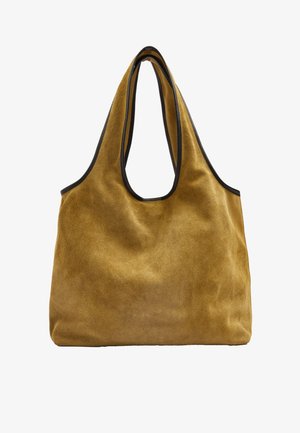 Brązowa torba typu tote z zamszu z czarną lamówką i szerokimi uchwytami, prosty i niesztywny design, pokazana na białym tle.