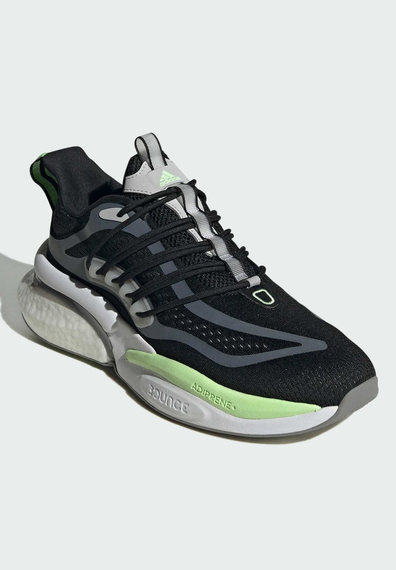 Baskets de sport noires avec une tige en mesh et des accents verts néon. Présentent une semelle intermédiaire gris clair et une semelle extérieure texturée distinctive.