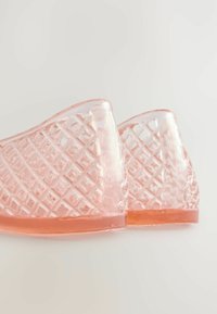 Transluzente rosa Hausschuhe mit einem strukturierten Diamantmuster, ausgestattet mit einer soliden rosa Sohle und offenem Rückendesign für Atmungsaktivität.
