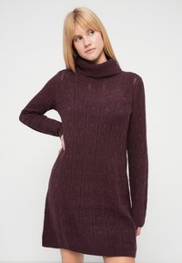 Strikket turtleneck-kjole i mørk burgunder med et strukturert diamantmønster, lange ermer og en avslappet passform.