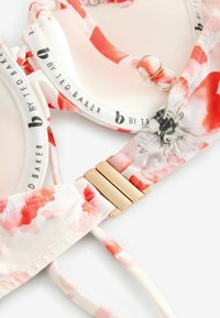 Top de bikini floral con tela suave y patrones en acuarela de tonos rosa y rojo. Incluye un cierre de tono dorado y tirantes ajustables.