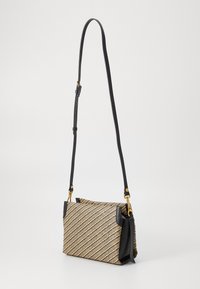 Borsa a busta in paglia intrecciata con un motivo a strisce diagonali beige e nere, dotata di dettagli in pelle e di una tracolla nera removibile.