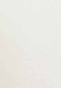 Rybkowany materiał w jasnym kremowym kolorze z subtelną teksturą, z pionowymi liniami na całej powierzchni. Miękki i elastyczny materiał.