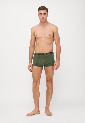 Groene katoenen boxershorts met een zwarte Moschino-logo tailleband. De pasvorm is snug, en de stof lijkt glad en zacht aan te voelen.