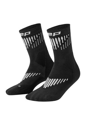 Pair of black athletic crew socks with white vertical stripe patterns and logo near the top cuff.