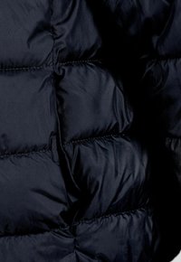Námorníckym modrý páperový kabát z textílie s prešívanými sekciami, hladkým povrchom a viditeľným šitím. Ľahký a izolovaný dizajn.