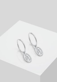 Silberne Creolen mit ovalen Anhängern, die mit filigranen Gravuren verz decorated sind. Die glatte Textur und der polierte Finish unterstreichen ihre reflektierende Qualität.