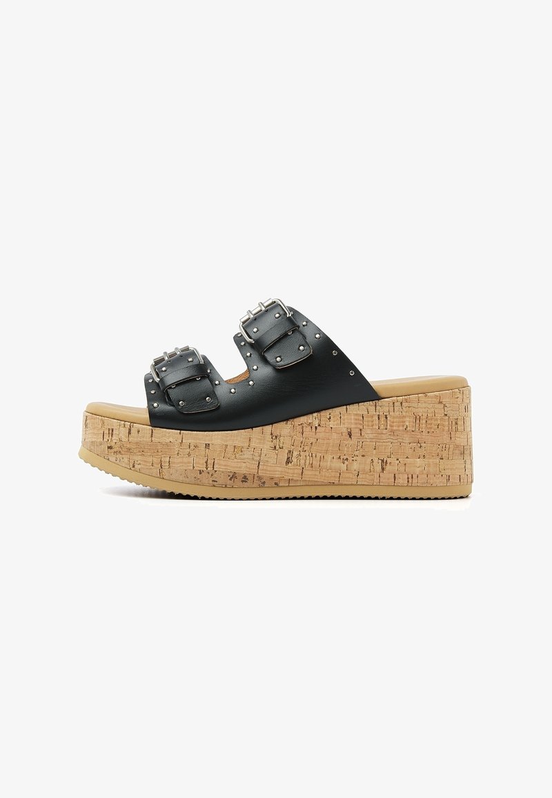 Sandale à plateforme en cuir noir avec semelle compensée en liège, deux boucles argentées et petits clous métalliques sur les brides.