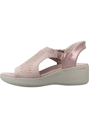 Sandalia cuña de color rosa claro con puntera abierta, parte superior de punto, tira ajustable, suela acolchada y diseño transpirable para comodidad y soporte.