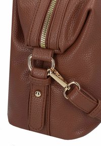 Bruine leren handtas met een gestructureerde textuur, een gouden ritssluiting, metalen accenten en een afneembare band. Het ontwerp heeft een geplooide vorm voor een moderne uitstraling.