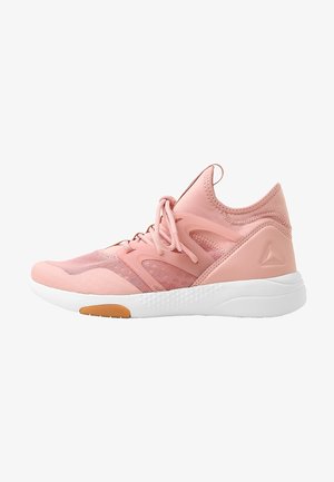 Baskets de sport rose clair avec empiècements en mesh et synthétique, fermeture à lacets sur le devant, semelle blanche texturée et logo discret au talon.