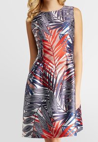 Robe sans manches au motif floral vibrant, avec des teintes rouges, bleues et blanches. Le design comprend de grandes formes de feuilles et des accents pointillés.