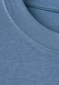 Niebieski bawełniany t-shirt o kroju crewneck z prążkowanym kołnierzykiem i gładką fakturą, o lekko luźnym kroju i minimalnych detalach szwów.