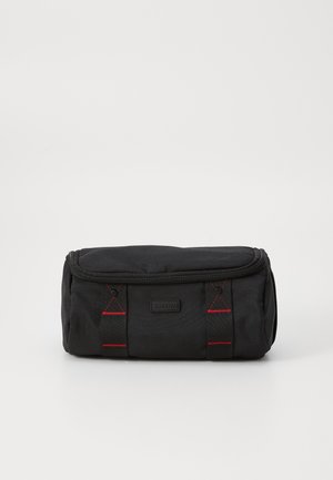 Black fabric storage bag with a zippered closure, featuring red stitching accents and side flaps for secure handling.