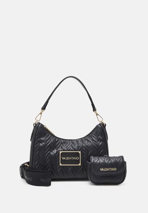 Quilted black leather handbag with a rounded shape, gold hardware, a logo plaque, and a detachable mini bag with a shoulder strap.