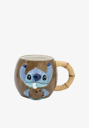 Tazza di ceramica marrone a forma di tiki con personaggio dei cartoni animati blu in rilievo che tiene una noce di cocco marrone davanti e manico curvo sul lato.