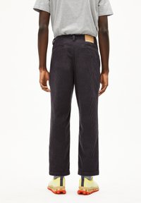 Donkergrijze corduroy broek met rechte pijpen, met een leren merklabel op de achterzijde van de taille en subtiele textuurstrepen.