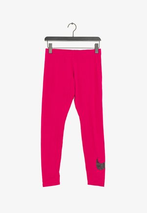 Jasnoróżowe legginsy wiszące na czarnym wieszaku z czarnym logo Nike Swoosh blisko lewego kostki.