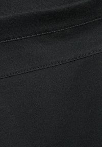 Tissu noir extensible avec une texture lisse, présentant un design simple et une couture plate sur le bord supérieur.