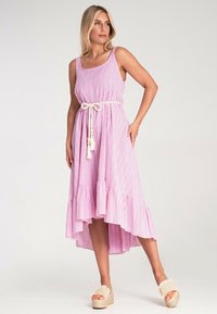 Pink-weiße gestreifte Midi-Kleid mit ausgestelltem Saum, verstellbarem Taillenzug mit Quasten und Trägern. Getragen mit neutralen Plateausandalen.