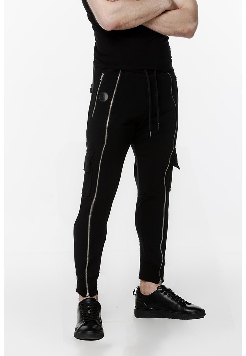 Czarne spodnie dresowe z zamkami błyskawicznymi, slim-fit, z kontrastującymi detalami zamków. Wykonane z miękkiego materiału z ściągaczami przy mankietach.